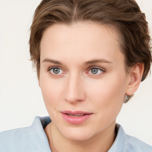 Joyful white young-adult female with short  brown hair and blue eyes