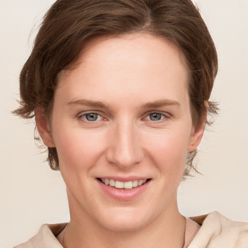 Joyful white young-adult female with medium  brown hair and grey eyes