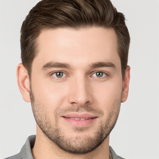 Joyful white young-adult male with short  brown hair and grey eyes