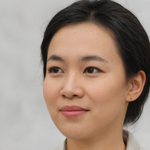 Joyful asian young-adult female with medium  brown hair and brown eyes