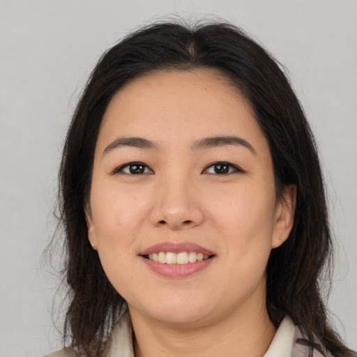 Joyful asian young-adult female with long  brown hair and brown eyes
