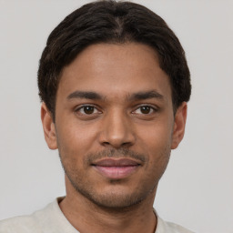 Joyful black young-adult male with short  brown hair and brown eyes