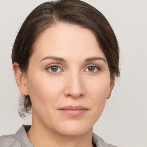 Joyful white young-adult female with medium  brown hair and grey eyes