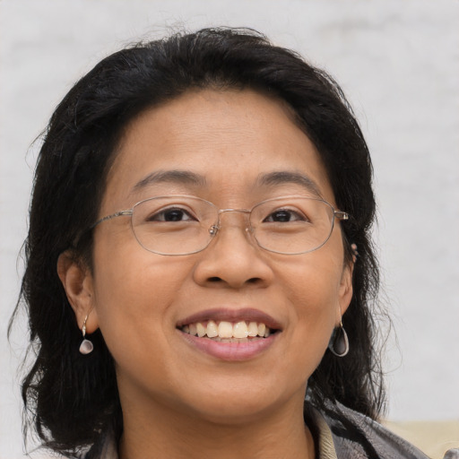 Joyful asian adult female with medium  brown hair and brown eyes