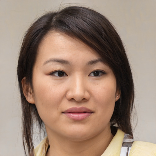 Joyful asian young-adult female with medium  brown hair and brown eyes