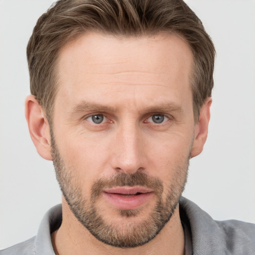 Joyful white adult male with short  brown hair and grey eyes