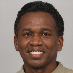 Joyful black adult male with short  brown hair and brown eyes