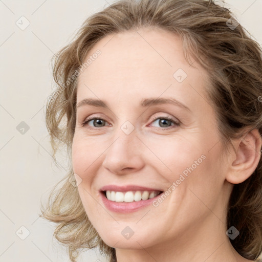 Joyful white young-adult female with medium  brown hair and blue eyes