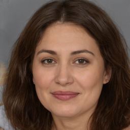 Joyful white adult female with long  brown hair and brown eyes