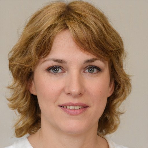 Joyful white young-adult female with medium  brown hair and blue eyes