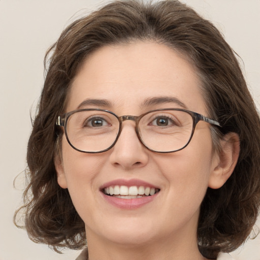 Joyful white adult female with medium  brown hair and green eyes