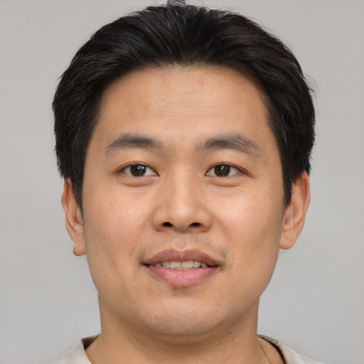 Joyful asian young-adult male with short  brown hair and brown eyes