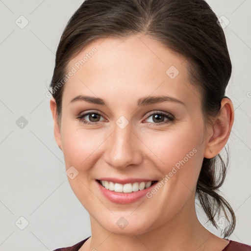 Joyful white young-adult female with medium  brown hair and grey eyes