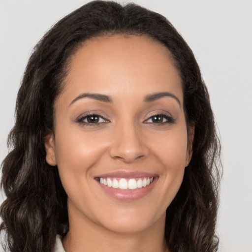 Joyful latino young-adult female with long  brown hair and brown eyes