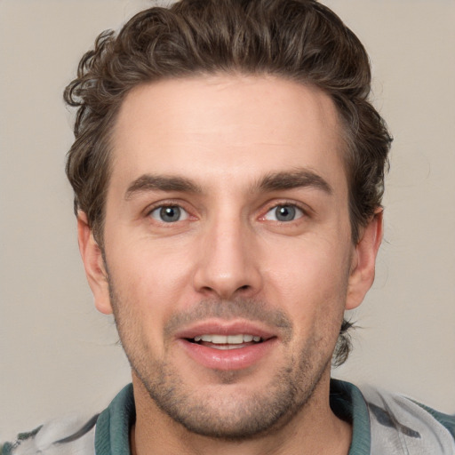 Joyful white young-adult male with short  brown hair and blue eyes