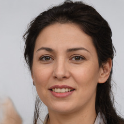 Joyful white adult female with long  brown hair and brown eyes