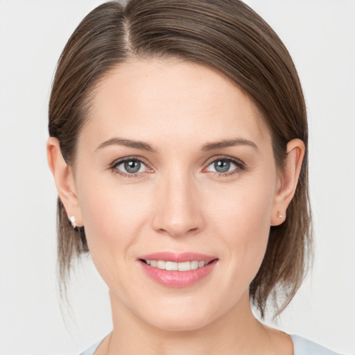 Joyful white young-adult female with medium  brown hair and grey eyes