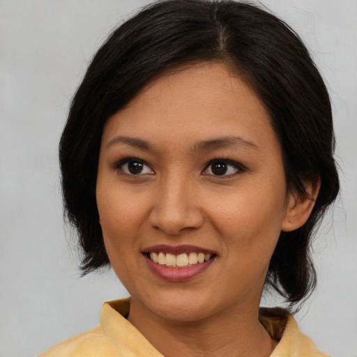Joyful latino young-adult female with medium  brown hair and brown eyes