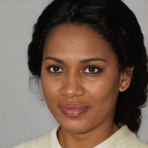 Joyful black adult female with medium  brown hair and brown eyes