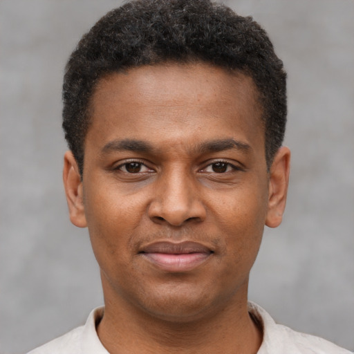 Joyful latino young-adult male with short  brown hair and brown eyes