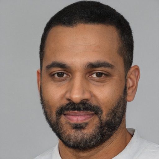 Joyful black young-adult male with short  black hair and brown eyes