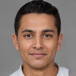 Joyful latino young-adult male with short  brown hair and brown eyes