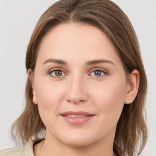 Joyful white young-adult female with medium  brown hair and grey eyes