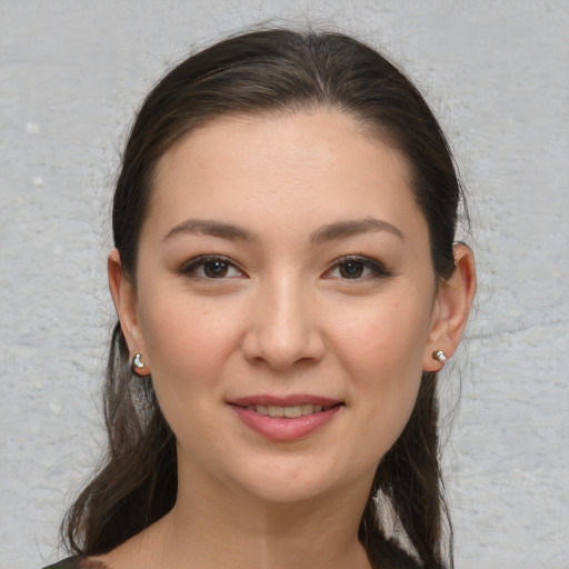 Joyful white young-adult female with long  brown hair and brown eyes