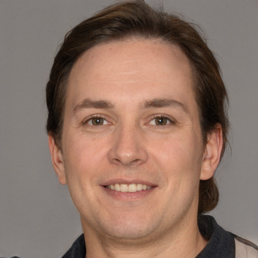 Joyful white adult male with short  brown hair and grey eyes