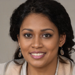 Joyful black young-adult female with long  brown hair and brown eyes