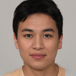 Joyful asian young-adult male with short  brown hair and brown eyes