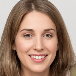 Joyful white young-adult female with long  brown hair and green eyes