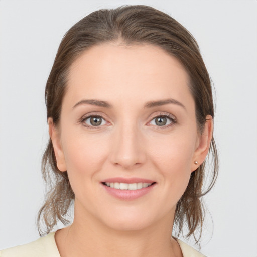 Joyful white young-adult female with medium  brown hair and grey eyes