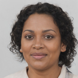 Joyful black adult female with medium  brown hair and brown eyes