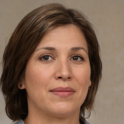 Joyful white adult female with medium  brown hair and brown eyes