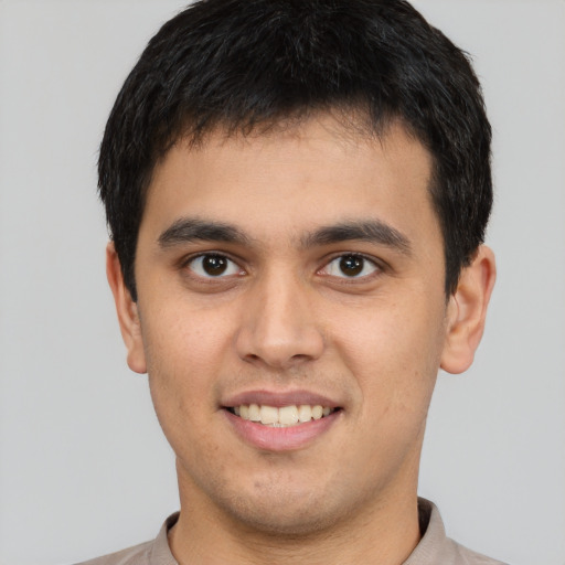 Joyful latino young-adult male with short  brown hair and brown eyes