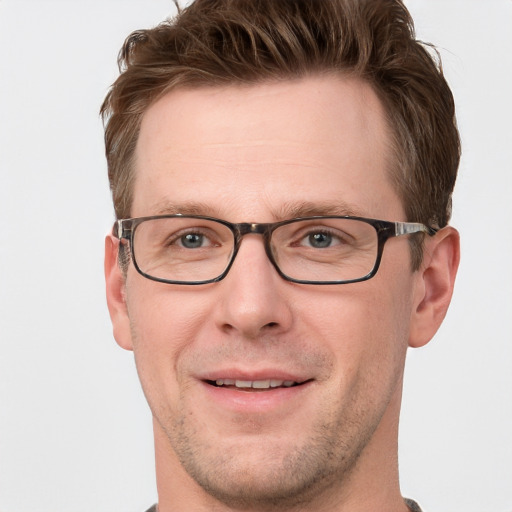 Joyful white adult male with short  brown hair and grey eyes