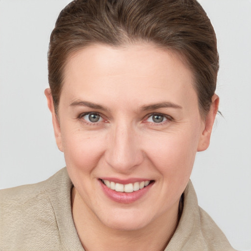 Joyful white young-adult female with short  brown hair and grey eyes