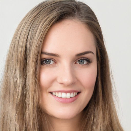 Joyful white young-adult female with long  brown hair and green eyes