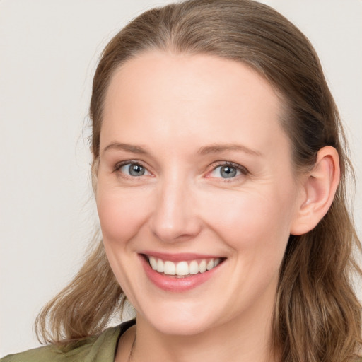 Joyful white young-adult female with long  brown hair and blue eyes