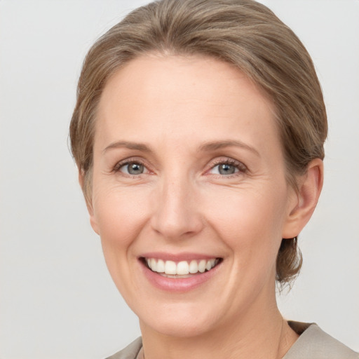 Joyful white adult female with medium  brown hair and grey eyes