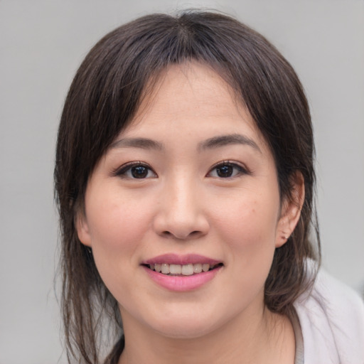 Joyful asian young-adult female with medium  brown hair and brown eyes