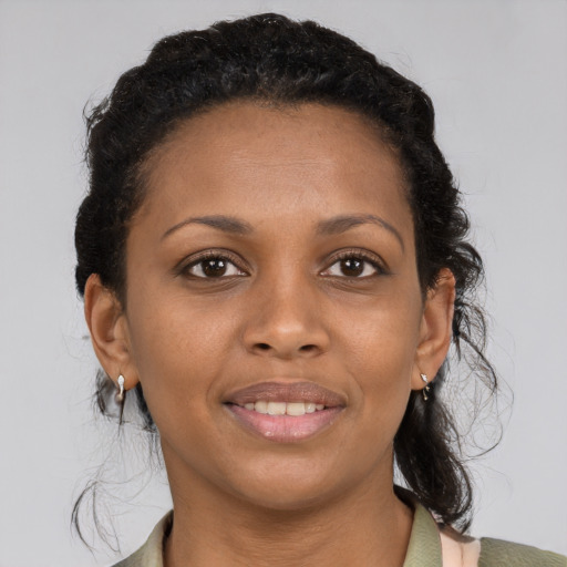 Joyful black young-adult female with short  brown hair and brown eyes