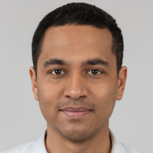 Joyful latino young-adult male with short  black hair and brown eyes