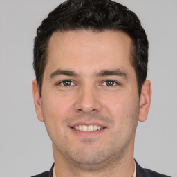 Joyful white young-adult male with short  brown hair and brown eyes