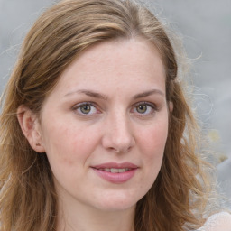 Joyful white young-adult female with long  brown hair and blue eyes