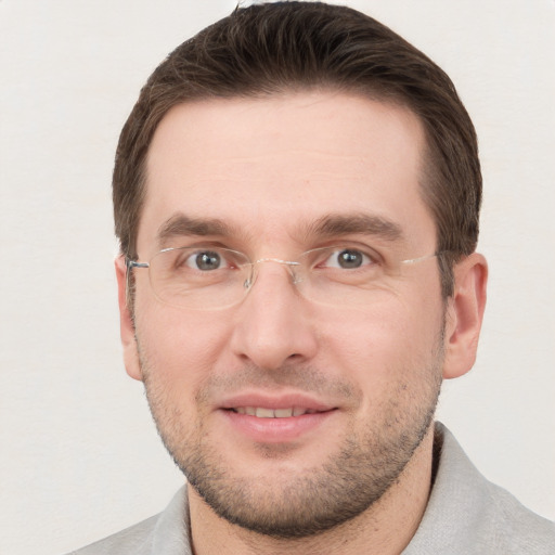 Joyful white young-adult male with short  brown hair and grey eyes