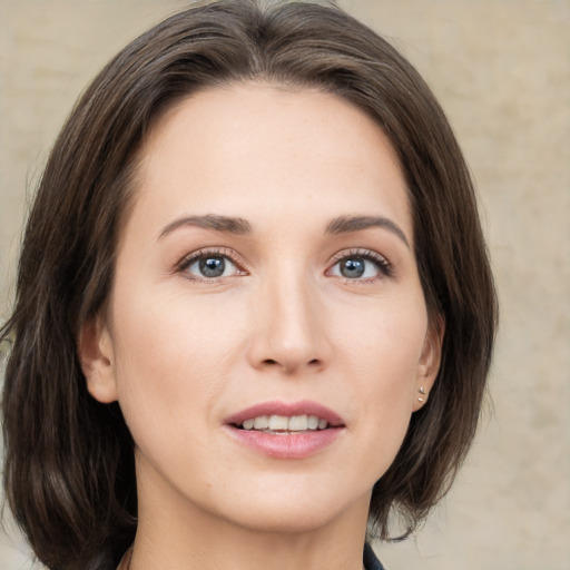 Joyful white young-adult female with medium  brown hair and green eyes