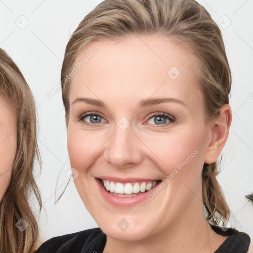 Joyful white young-adult female with medium  brown hair and blue eyes