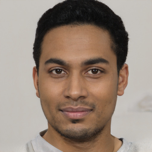 Joyful latino young-adult male with short  black hair and brown eyes